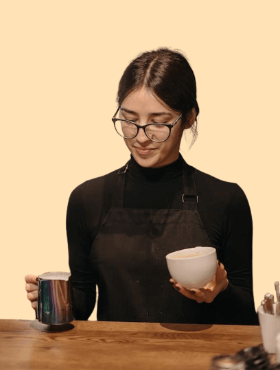 Chica de anteojos por servir cafe de un jarrito a una taza 