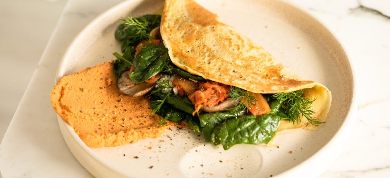 Plate with a folded omelette and greens